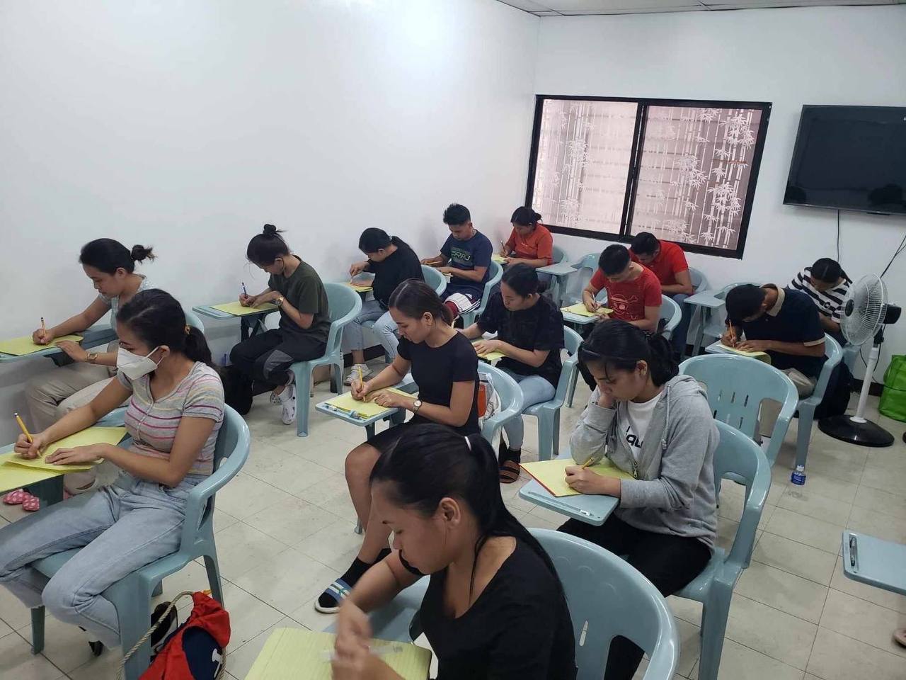 Desk with leather desk pad, walnut desk organizer, wireless keyboard and mouse, and porcelain mug.